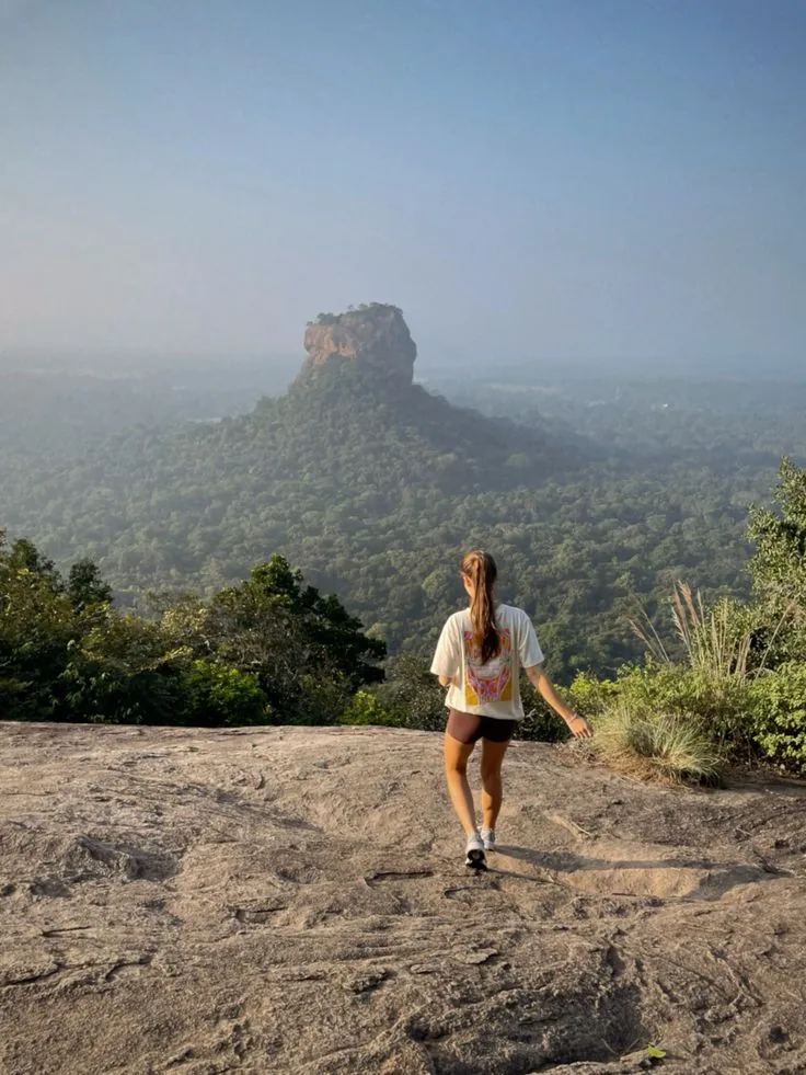 A traveller at a rocky viewpoint overlooking Sigiriya