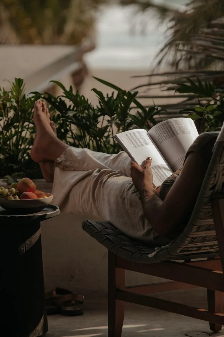 A traveller reading beside a tropical retreat pool