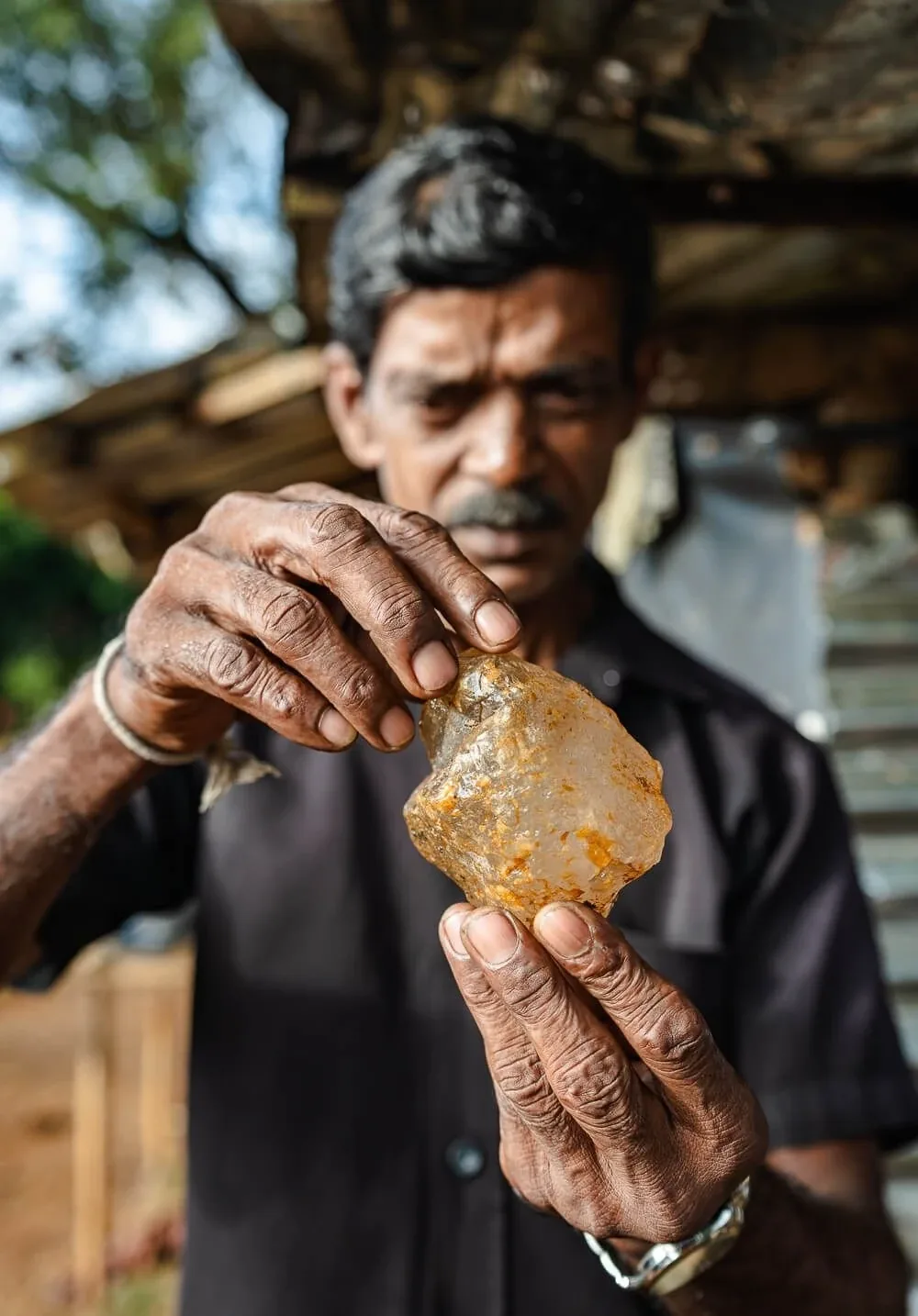 A man examining a large rough stone in his hands