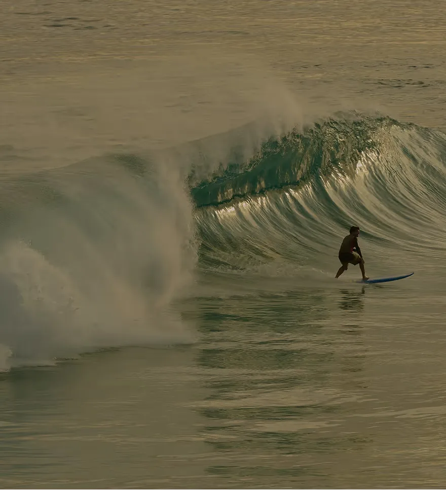 A surfer riding a wave along Sri Lanka's coast