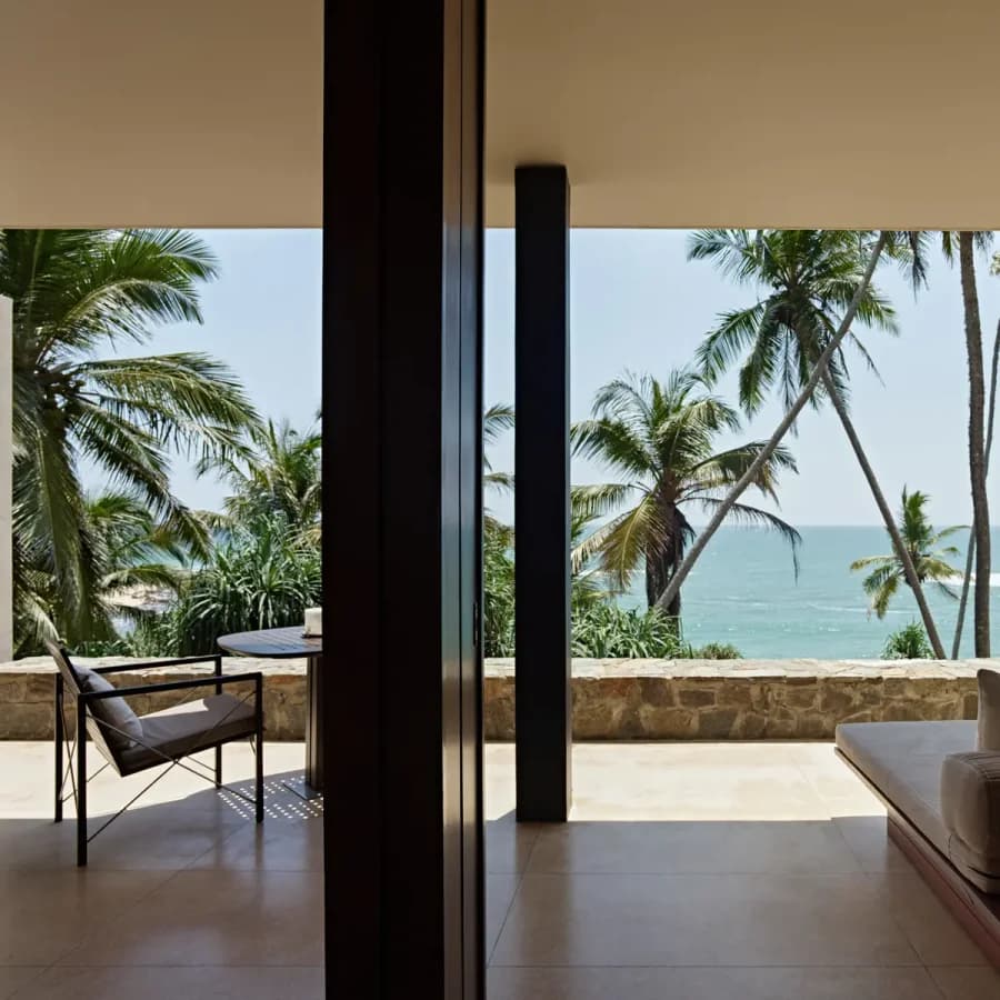 Suite with ocean view towards palm trees and Indian Ocean at Amanwella, Sri Lanka.