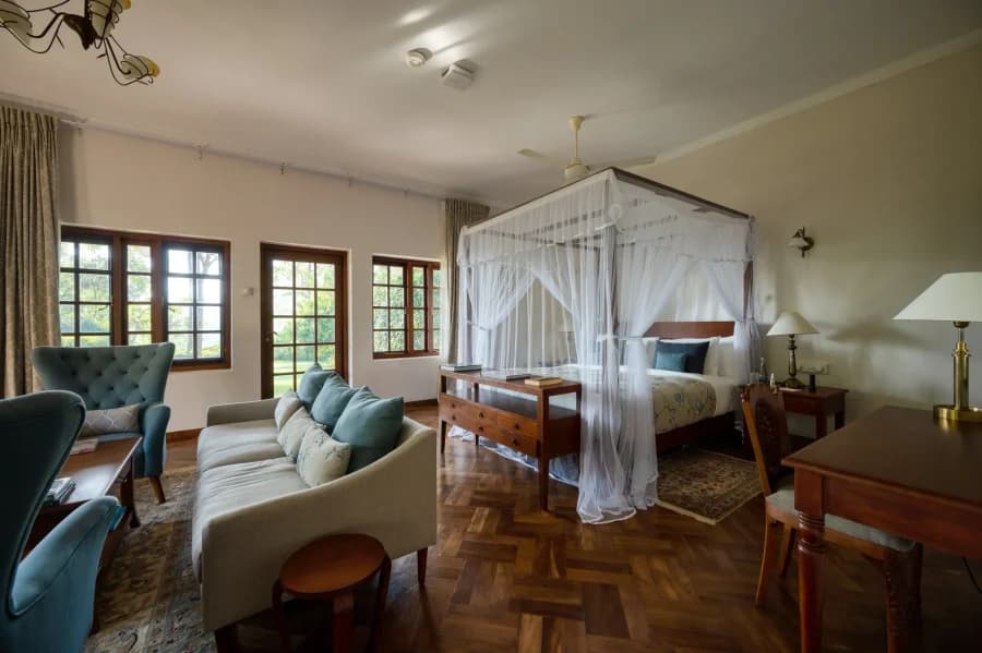 Master Suite with a four-poster bed and polished timber floors at Ceylon Tea Trails